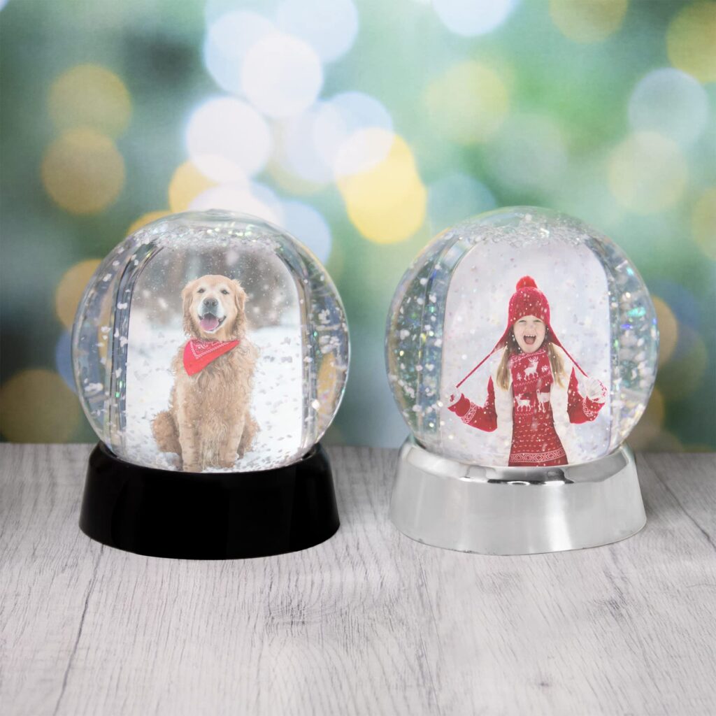 Make your own snow globe by customizing the base with a photo, drawing, embroidery, monogram, or anything else you can think of! This create-a-globe is made out of durable plastic, NOT glass so it's sticky-finger friendly! The globe holds two 2x3 photos, one on each side and includes 4 pre-printed inserts for the snow globe base or you can create your own. The base pulls off to insert photos and there are little latches on the bottom to insert your own base design. The globe comes pre-filled with distilled water, white snow flecks, and translucent glitter flecks.